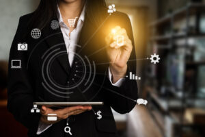 A woman holding a tablet with technology icons surrounding her.