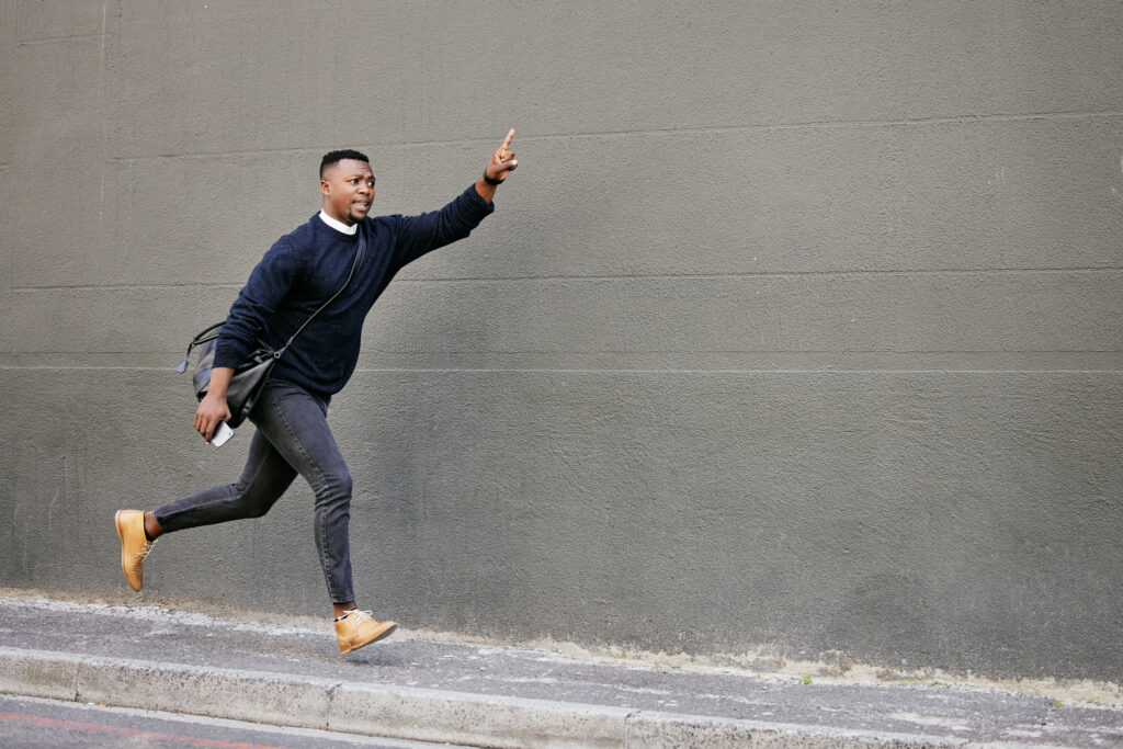 A man running with his hand pointing up.